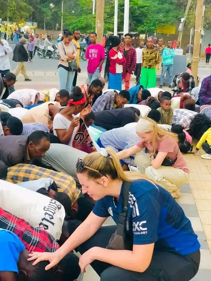 Sidney Switzer praying with the local community